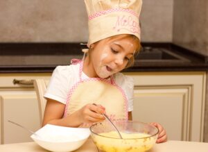 girl, kid preparing food in the kitchen. cooking concept, learning